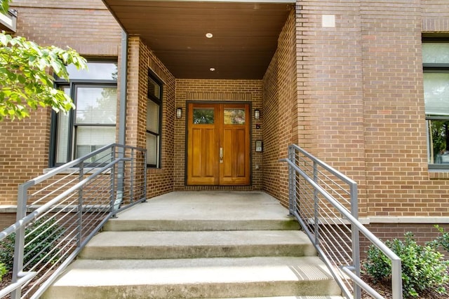 doorway to property featuring brick siding