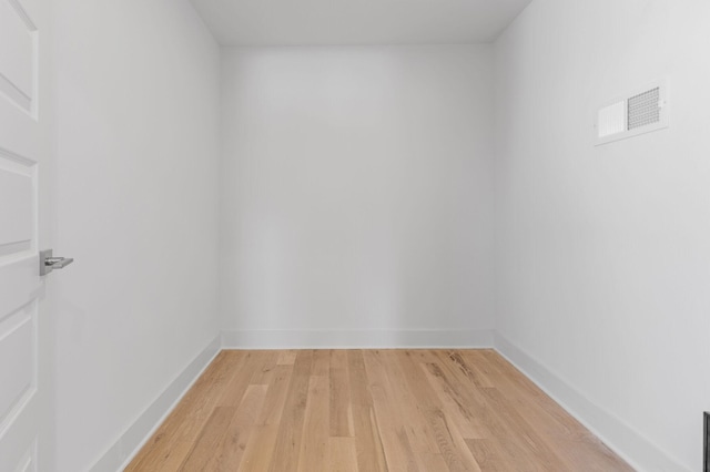 empty room featuring visible vents, light wood-style flooring, and baseboards