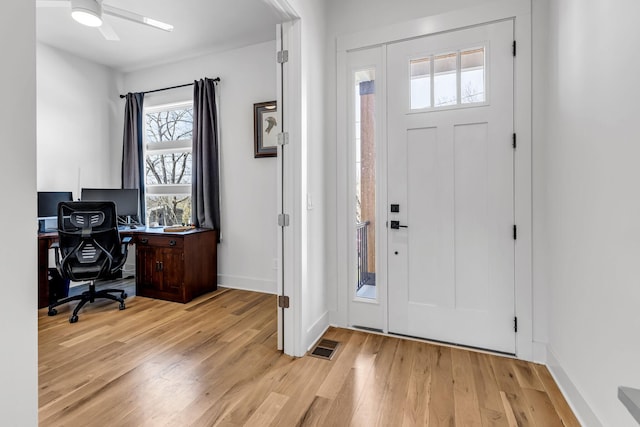 entryway featuring light wood-style floors, baseboards, visible vents, and a ceiling fan