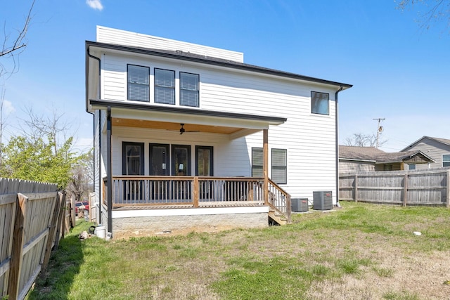 rear view of property featuring a fenced backyard, central AC, a ceiling fan, and a yard