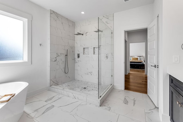 bathroom with marble finish floor, a marble finish shower, baseboards, and a freestanding bath