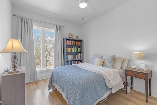 bedroom with multiple windows, visible vents, and wood finished floors