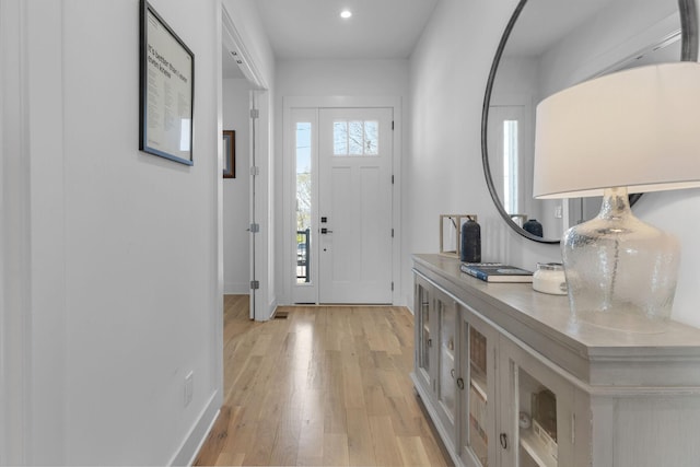 foyer entrance with light wood finished floors, recessed lighting, and baseboards