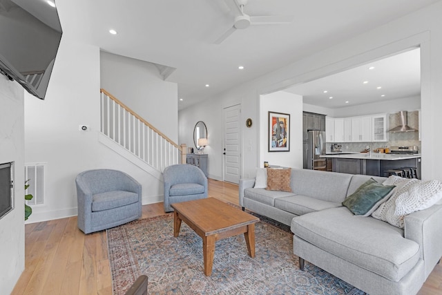 living room with light wood finished floors, stairway, visible vents, and recessed lighting