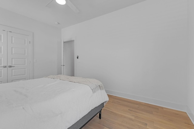 bedroom featuring light wood finished floors, baseboards, and a ceiling fan