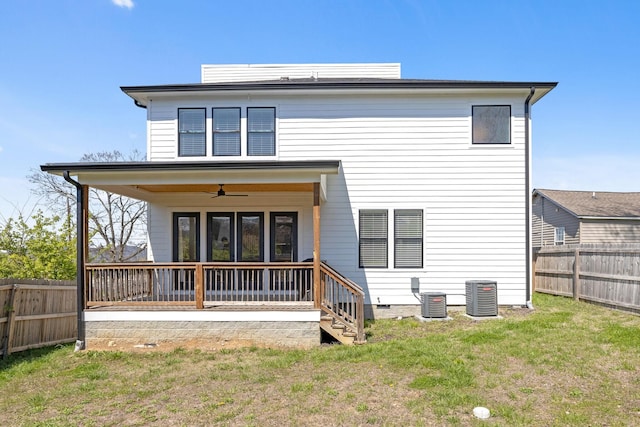 back of house featuring a fenced backyard, ceiling fan, central AC, and a lawn