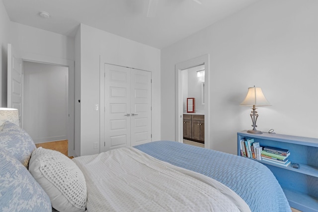 bedroom with ensuite bathroom, a closet, and a ceiling fan