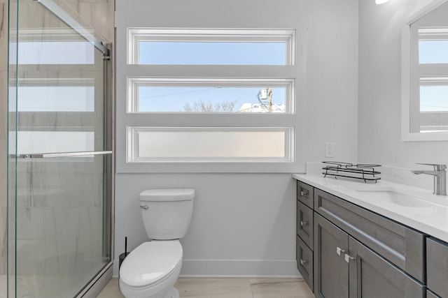 full bath with toilet, a baseboard heating unit, vanity, baseboards, and a shower stall