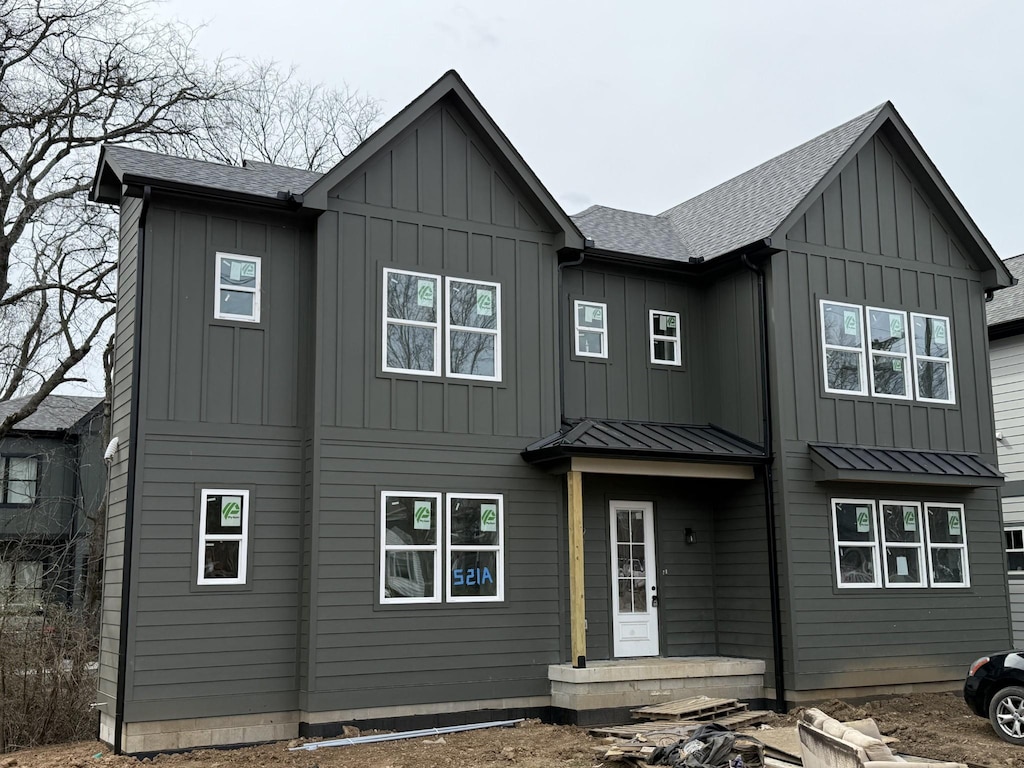 modern farmhouse featuring a standing seam roof, a shingled roof, metal roof, and board and batten siding