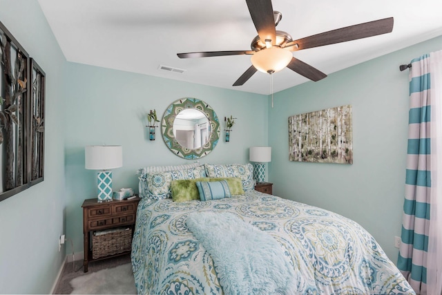 carpeted bedroom featuring a ceiling fan, visible vents, and baseboards