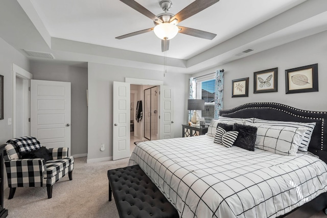 bedroom featuring carpet floors, a tray ceiling, visible vents, and baseboards