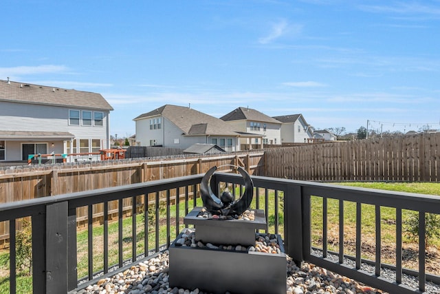 wooden terrace featuring a residential view and a fenced backyard