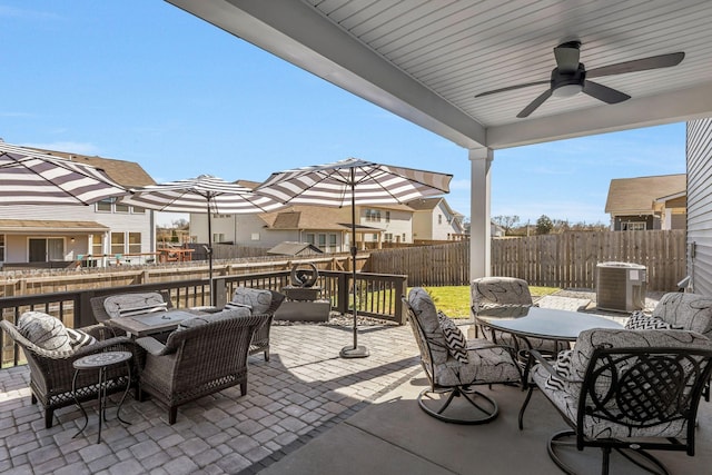 view of patio / terrace featuring outdoor dining area, outdoor lounge area, central AC unit, ceiling fan, and a fenced backyard