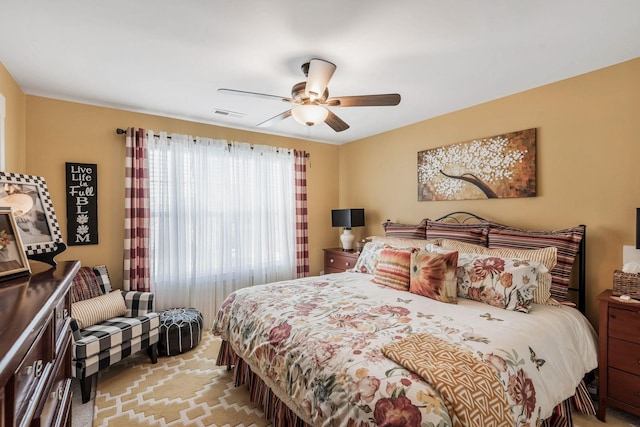 bedroom with ceiling fan, visible vents, and light colored carpet