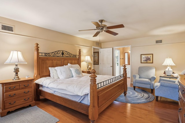 bedroom with ceiling fan, wood finished floors, and visible vents