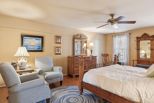 bedroom featuring ceiling fan, baseboards, and wood finished floors