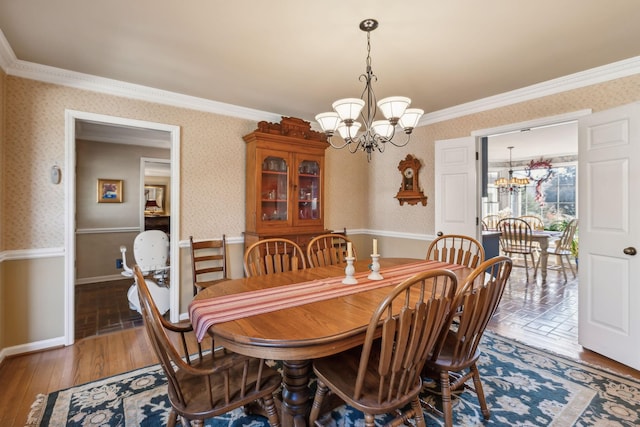 dining space featuring a chandelier, ornamental molding, light wood-type flooring, and wallpapered walls