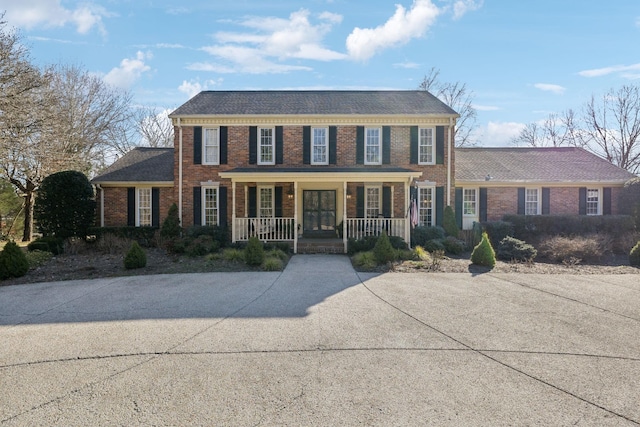 view of front of house featuring covered porch and brick siding