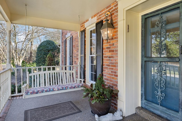 exterior space featuring covered porch and brick siding