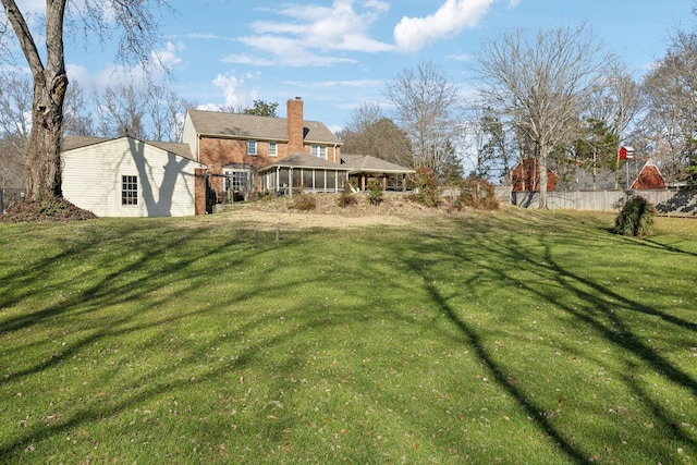 view of yard featuring a sunroom and fence