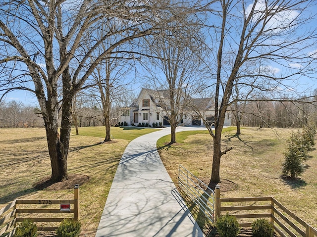 exterior space with driveway, a fenced front yard, and a lawn