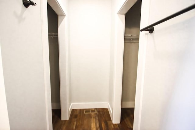 walk in closet with visible vents and dark wood finished floors