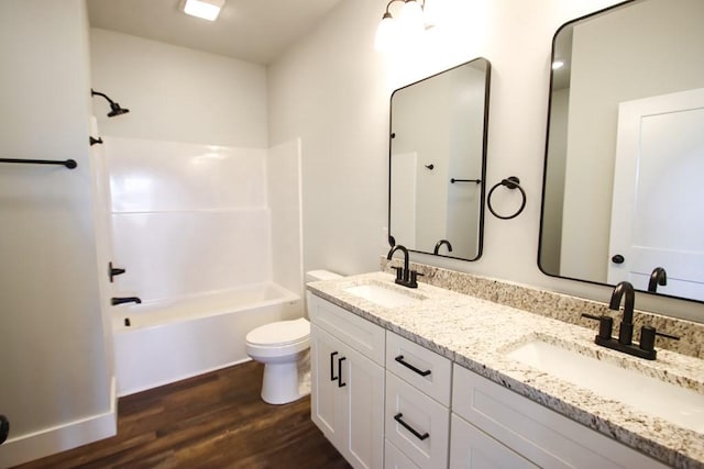 full bathroom with toilet, shower / washtub combination, a sink, and wood finished floors