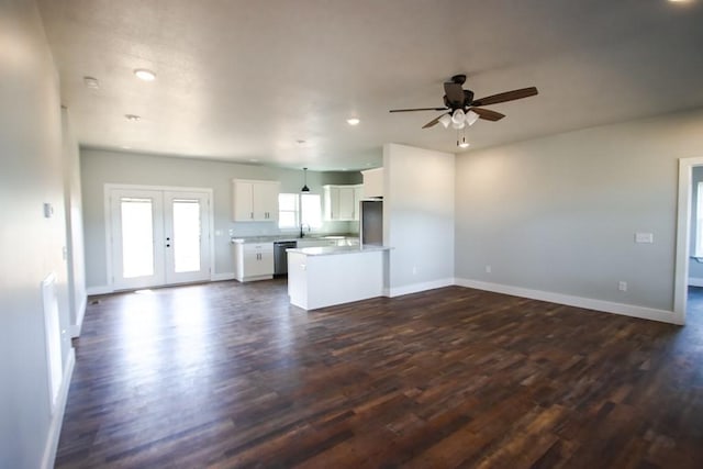 unfurnished living room featuring baseboards, ceiling fan, dark wood-type flooring, french doors, and a sink