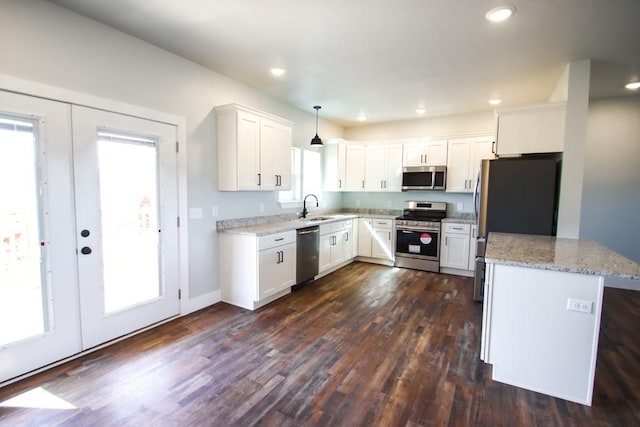 kitchen featuring stainless steel appliances, dark wood-type flooring, a sink, white cabinets, and french doors