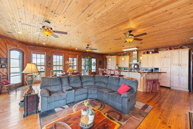 living room with wood ceiling, visible vents, wooden walls, and hardwood / wood-style floors