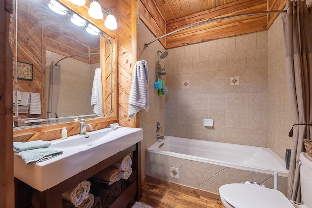 bathroom featuring tiled shower / bath, wood finished floors, vanity, and toilet