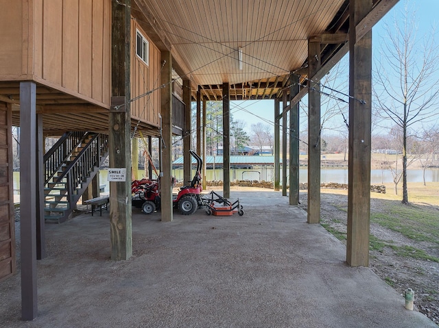 view of patio featuring a water view and stairway