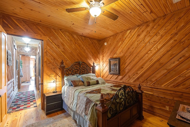 bedroom with wooden ceiling, light wood finished floors, wooden walls, and a ceiling fan