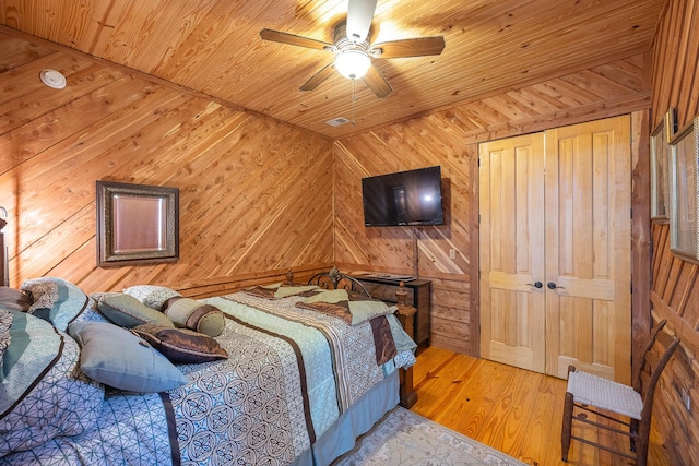 bedroom with wood ceiling and wooden walls