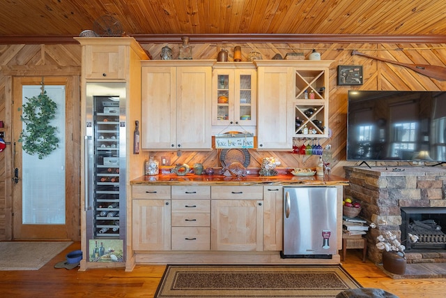 kitchen featuring wooden ceiling, stainless steel fridge, wine cooler, and wooden walls