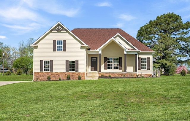 view of front of home featuring a shingled roof and a front yard