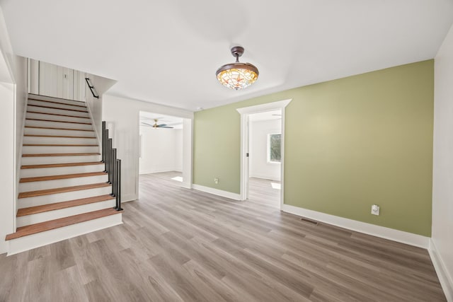 interior space with visible vents, stairway, light wood-style flooring, and baseboards