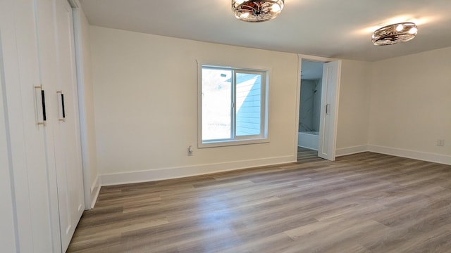 unfurnished bedroom with baseboards and wood finished floors