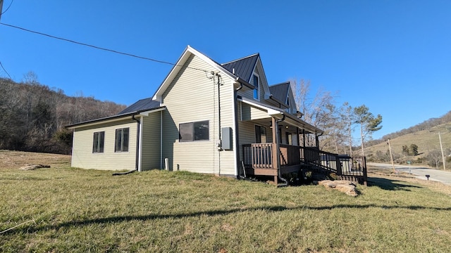 view of property exterior with metal roof and a yard