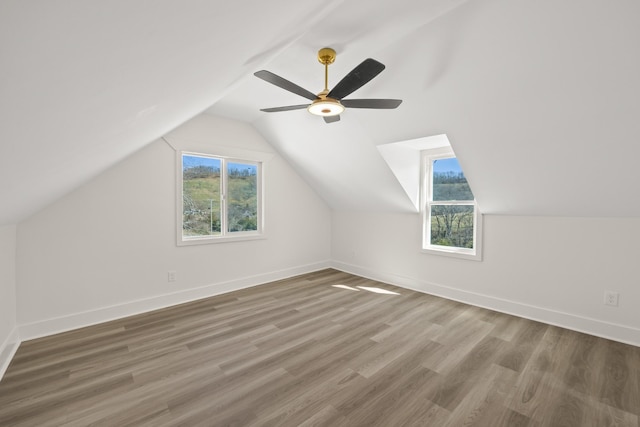 bonus room with a ceiling fan, lofted ceiling, baseboards, and wood finished floors