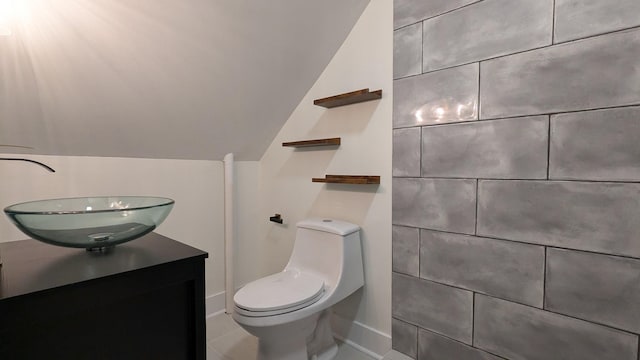 bathroom with vaulted ceiling, vanity, and toilet