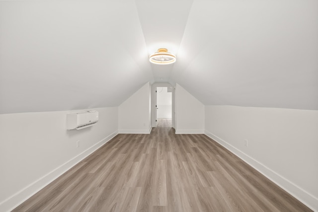 additional living space featuring lofted ceiling, wood finished floors, and baseboards