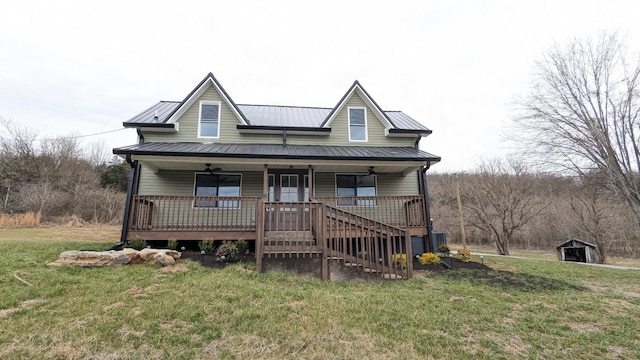 view of front of property featuring covered porch, ceiling fan, a front yard, and a standing seam roof