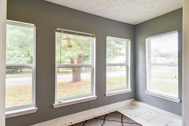 interior space with a textured ceiling and baseboards