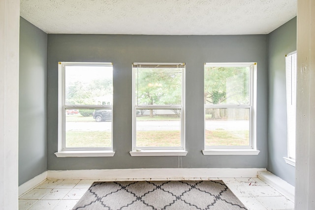 interior space featuring a textured ceiling and baseboards