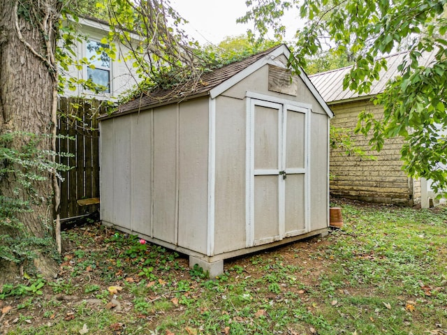 view of shed featuring fence