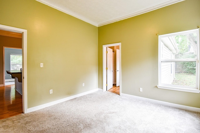 unfurnished room featuring carpet, ornamental molding, and baseboards