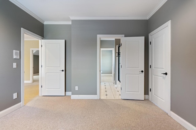 unfurnished bedroom with baseboards, ornamental molding, and light colored carpet