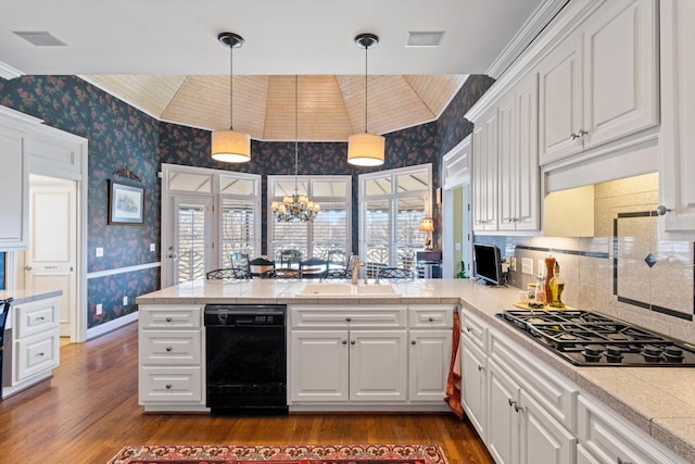 kitchen with white cabinetry, a sink, black appliances, and wallpapered walls