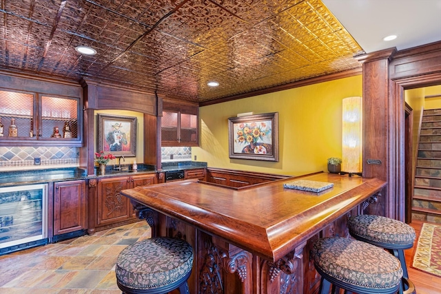 bar with ornamental molding, beverage cooler, a bar, and an ornate ceiling